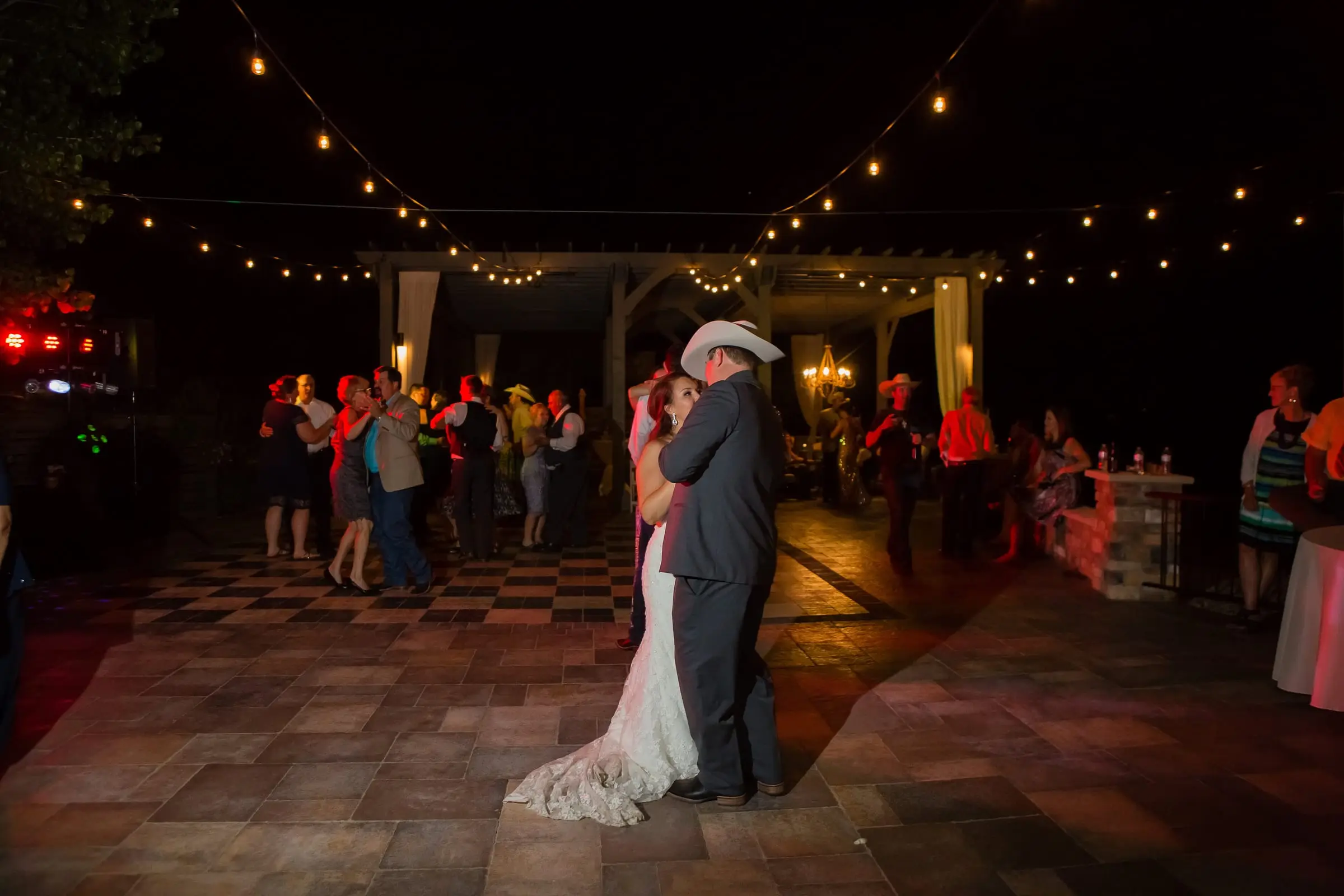 A couple dancing under string lights