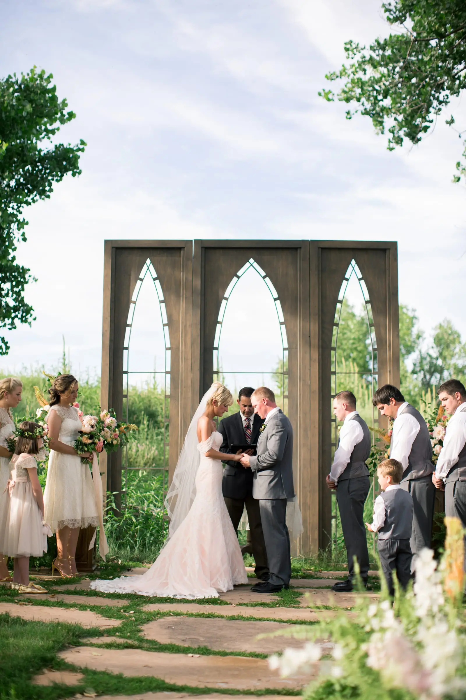 A couple at the altar under the cathedral windows in The Glen