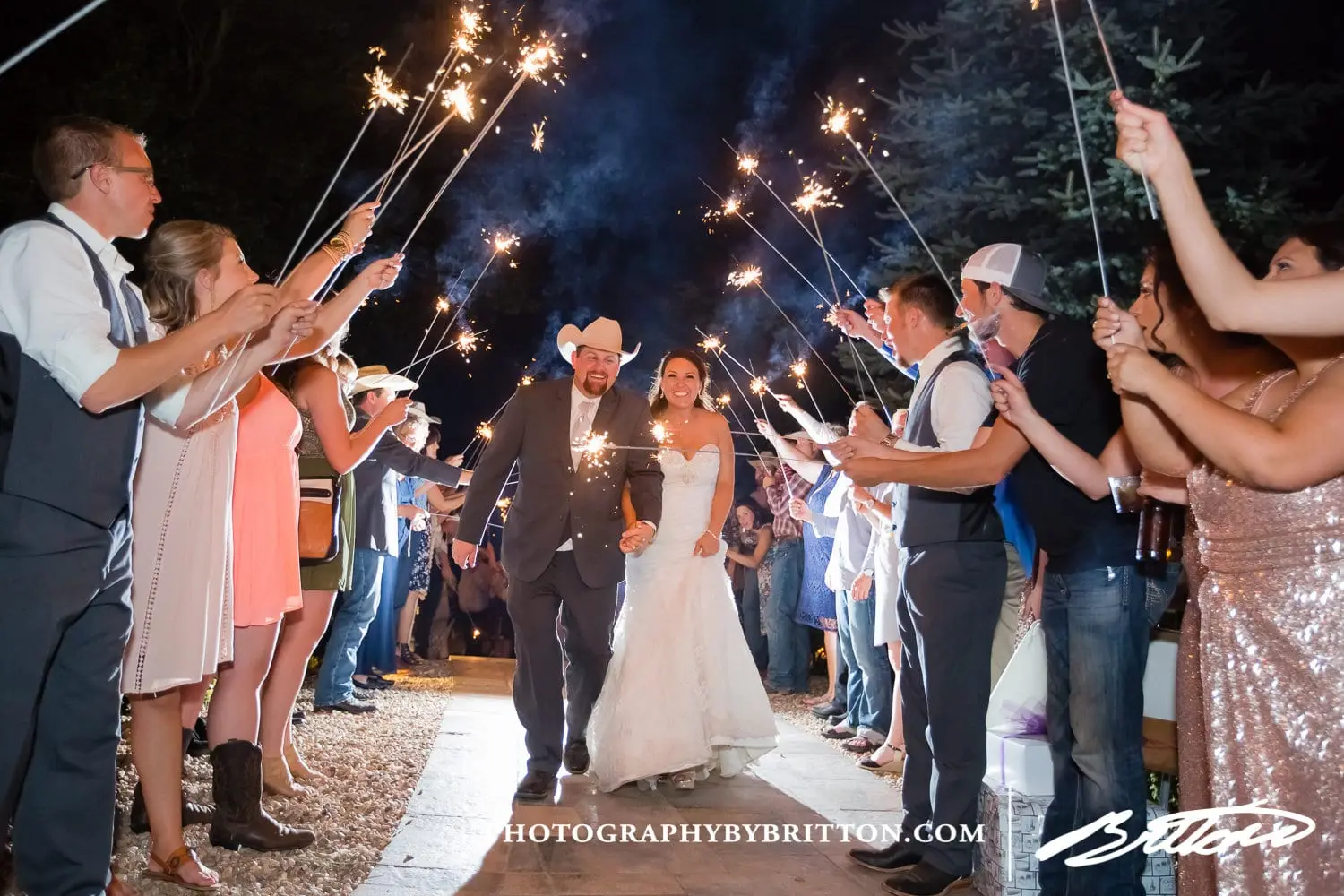 Guests holding sparklers as the couple leaves